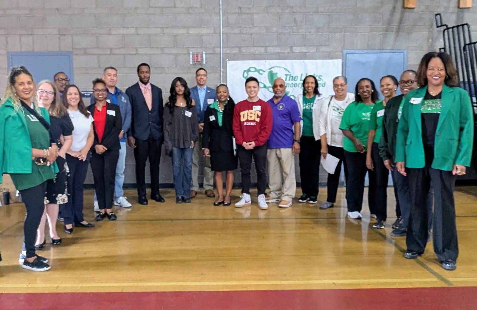 Members of the Channel Islands Chapter of The Links, Incorporated stand in a semicircle in a school gym during an enrichment day